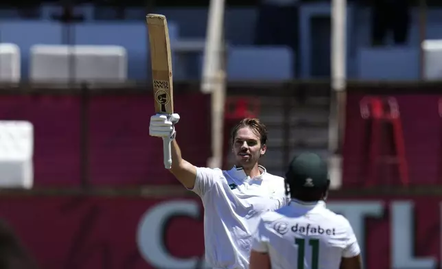 South Africa's Tristan Stubbs raises his bat after reaching his century during the third day of the first Test cricket match between South Africa and Sri Lanka, at Kingsmead stadium in Durban, South Africa, Friday, Nov. 29, 2024. (AP Photo/Themba Hadebe)