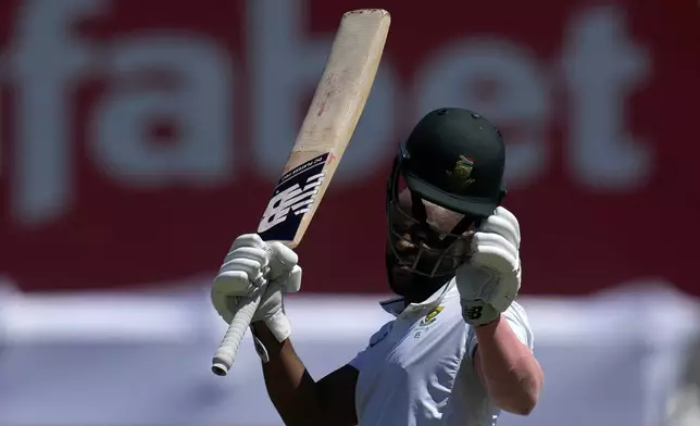 South Africa's captain Temba Bavuma raises his bat after reaching his century during the third day of the first Test cricket match between South Africa and Sri Lanka, at Kingsmead stadium in Durban, South Africa, Friday, Nov. 29, 2024. (AP Photo/Themba Hadebe)