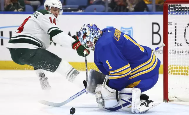 Buffalo Sabres goaltender Ukko-Pekka Luukkonen (1) stops Minnesota Wild center Joel Eriksson Ek (14) during the second period of an NHL hockey game Wednesday, Nov. 27, 2024, in Buffalo, N.Y. (AP Photo/Jeffrey T. Barnes)