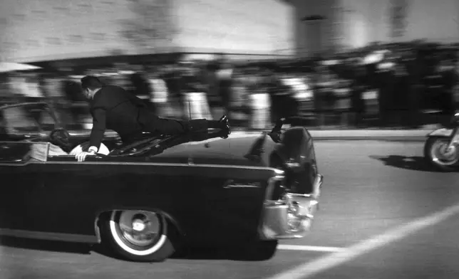 FILE - The limousine carrying mortally wounded President John F. Kennedy races toward the hospital seconds after he was shot, Nov. 22, 1963, in Dallas. The 60th anniversary of President Kennedy's assassination, marked on Wednesday, Nov. 22, 2023, finds his family, and the country, at a moment many would not have imagined in JFK's lifetime. (AP Photo/Justin Newman, File)