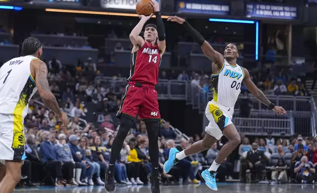 Miami Heat guard Tyler Herro (14) shoots in front of Indiana Pacers guard Bennedict Mathurin (00) during the first half of an NBA basketball game in Indianapolis, Sunday, Nov. 17, 2024. (AP Photo/Michael Conroy)