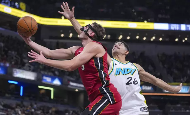 Miami Heat forward Nikola Jovic shoots in front of Indiana Pacers guard Ben Sheppard (26) during the first half of an NBA basketball game in Indianapolis, Sunday, Nov. 17, 2024. (AP Photo/Michael Conroy)