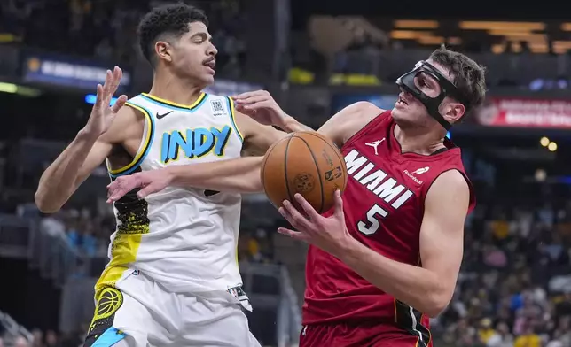 Miami Heat forward Nikola Jovic (5) tries to get past Indiana Pacers guard Ben Sheppard, left, during the first half of an NBA basketball game in Indianapolis, Sunday, Nov. 17, 2024. (AP Photo/Michael Conroy)