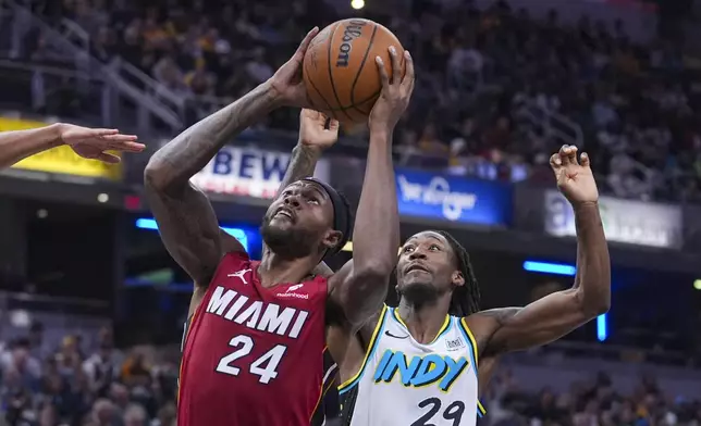 Miami Heat forward Haywood Highsmith (24) shoots in front of Indiana Pacers guard Quenton Jackson (29) during the first half of an NBA basketball game in Indianapolis, Sunday, Nov. 17, 2024. (AP Photo/Michael Conroy)