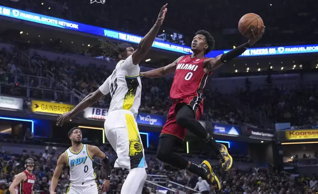 Miami Heat guard Josh Richardson (0) shoots over Indiana Pacers center Myles Turner during the first half of an NBA basketball game in Indianapolis, Sunday, Nov. 17, 2024. (AP Photo/Michael Conroy)