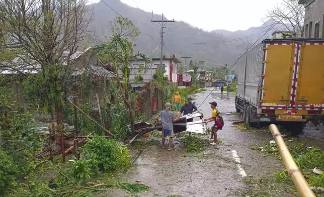 In this photo provided by the MDRRMO Viga Catanduanes, residents try to fix their damaged homes caused by Typhoon Man-yi in Viga, Catanduanes province, northeastern Philippines Sunday, Nov. 17, 2024. (MDRRMO Viga Catanduanes via AP)