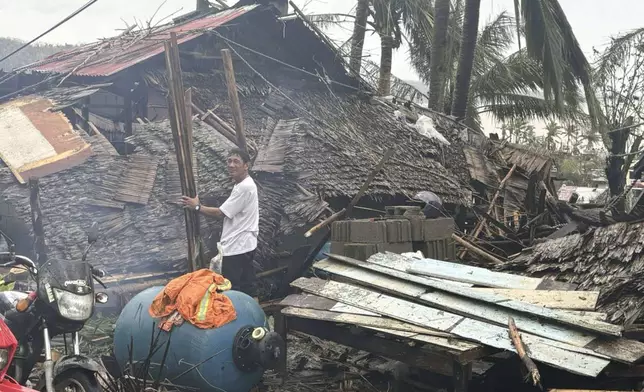 In this photo provided by the MDRRMO Viga Catanduanes, a resident stands beside a damaged house caused by Typhoon Man-yi in Viga, Catanduanes province, northeastern Philippines Sunday, Nov. 17, 2024. (MDRRMO Viga Catanduanes via AP)