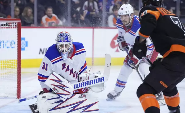 New York Rangers' Igor Shesterkin (31) blocks a shot by Philadelphia Flyers' Tyson Foerster (71) as Ryan Lindgren (55)looks on during the second period of an NHL hockey game, Friday, Nov. 29, 2024, in Philadelphia. (AP Photo/Matt Slocum)