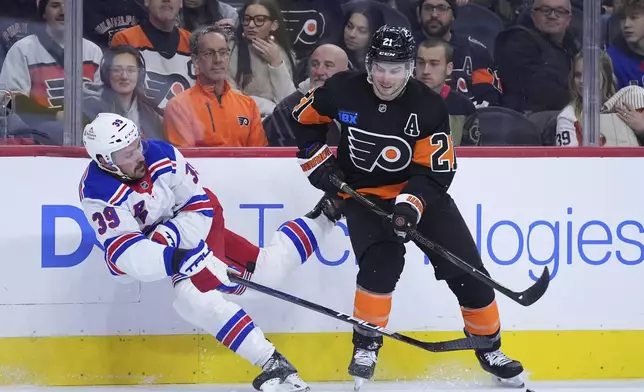 New York Rangers' Sam Carrick, left, passes around Philadelphia Flyers' Scott Laughton during the first period of an NHL hockey game, Friday, Nov. 29, 2024, in Philadelphia. (AP Photo/Matt Slocum)