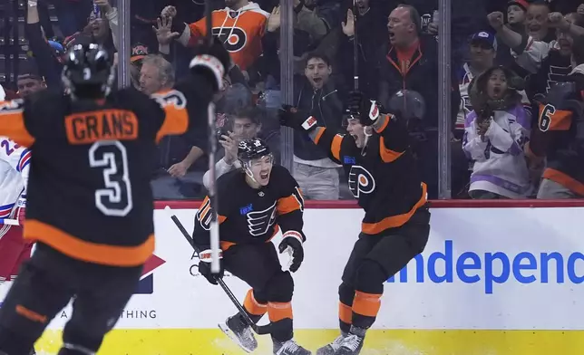 Philadelphia Flyers' Bobby Brink, center, celebrates with Tyson Foerster, right, and Helge Grans after scoring a goal during the first period of an NHL hockey game against the New York Rangers, Friday, Nov. 29, 2024, in Philadelphia. (AP Photo/Matt Slocum)