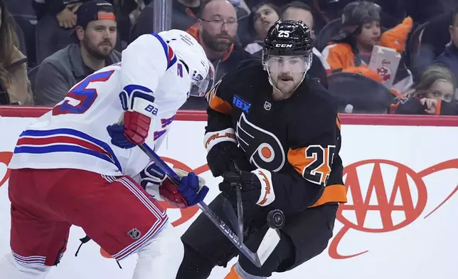 Philadelphia Flyers' Ryan Poehling, right, and New York Rangers' Ryan Lindgren battle for the puck during the second period of an NHL hockey game, Friday, Nov. 29, 2024, in Philadelphia. (AP Photo/Matt Slocum)