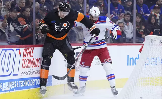 New York Rangers' Sam Carrick, right, and Philadelphia Flyers' Helge Grans collide during the first period of an NHL hockey game, Friday, Nov. 29, 2024, in Philadelphia. (AP Photo/Matt Slocum)