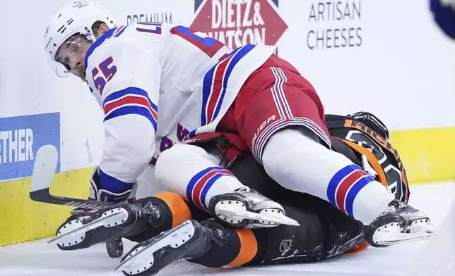 New York Rangers' Ryan Lindgren, top, collides with Philadelphia Flyers' Matvei Michkov during the second period of an NHL hockey game, Friday, Nov. 29, 2024, in Philadelphia. (AP Photo/Matt Slocum)