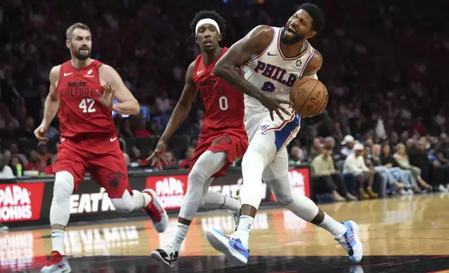 Philadelphia 76ers forward Paul George (8) goes to the basket as Miami Heat guard Josh Richardson (0) defends during the first half of an NBA basketball game, Monday, Nov. 18, 2024, in Miami. (AP Photo/Lynne Sladky)