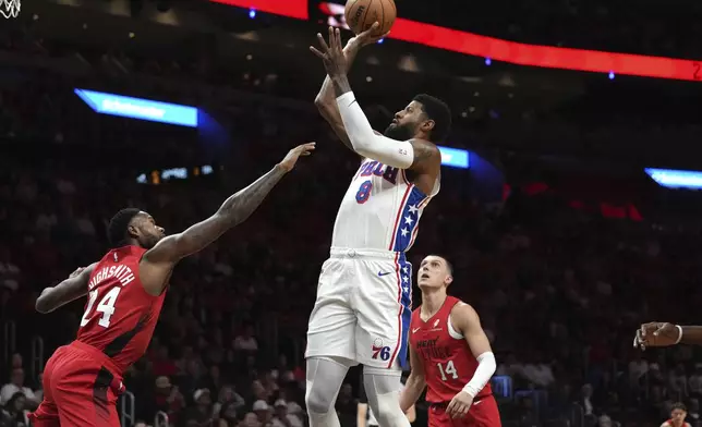 Philadelphia 76ers forward Paul George (8) goes to the base as Miami Heat guard Tyler Herro (14) defends during the first half of an NBA basketball game, Monday, Nov. 18, 2024, in Miami. (AP Photo/Lynne Sladky)