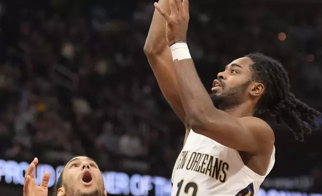 New Orleans Pelicans guard Antonio Reeves (12) shoots in front of Cleveland Cavaliers forward Jaylon Tyson (24) in the first half of an NBA basketball game, Wednesday, Nov. 20, 2024, in Cleveland. (AP Photo/Sue Ogrocki)