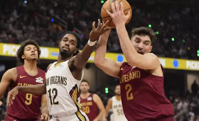 Cleveland Cavaliers guard Ty Jerome (2) takes the ball from New Orleans Pelicans guard Antonio Reeves (12) in the first half of an NBA basketball game, Wednesday, Nov. 20, 2024, in Cleveland. (AP Photo/Sue Ogrocki)