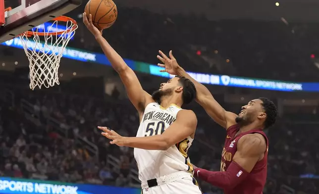 New Orleans Pelicans forward Jeremiah Robinson-Earl (50) goes to the basket in front of Cleveland Cavaliers guard Donovan Mitchell, right, in the first half of an NBA basketball game, Wednesday, Nov. 20, 2024, in Cleveland. (AP Photo/Sue Ogrocki)