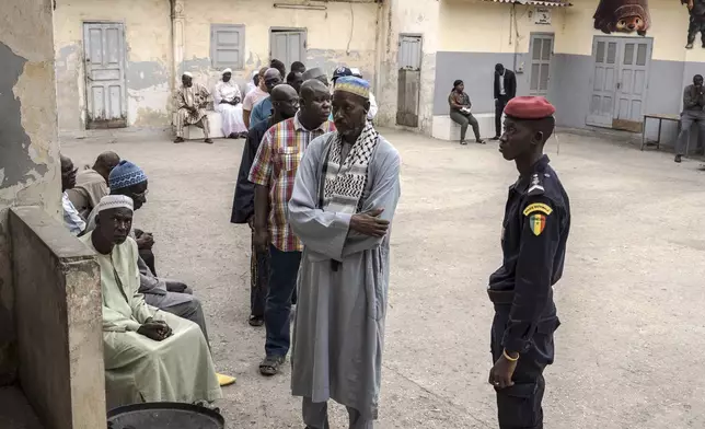 People wait to cast their ballot for legislative elections in Dakar, Senegal Sunday, Nov. 17, 2024. (AP Photo/Annika Hammerschlag)