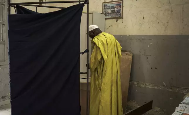 A man casts his vote for legislative elections, at a polling station in Dakar, Senegal Sunday, Nov. 17, 2024. (AP Photo/Annika Hammerschlag)