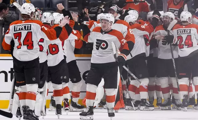 Philadelphia Flyers players celebrate the team's 3-2 overtime win against the Nashville Predators in an NHL hockey game Wednesday, Nov. 27, 2024, in Nashville, Tenn. (AP Photo/George Walker IV)