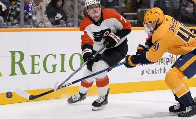 Nashville Predators center Fedor Svechkov, right, hits the puck away from Philadelphia Flyers right wing Owen Tippett (74) during the first period of an NHL hockey game Wednesday, Nov. 27, 2024, in Nashville, Tenn. (AP Photo/George Walker IV)