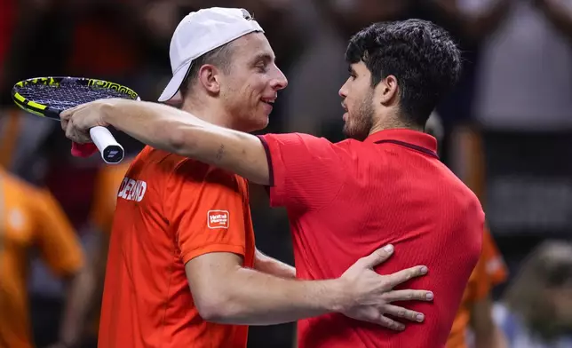 Spain's tennis player Carlos Alcaraz hugs Netherlands' Tallon Griekspoor after a Davis Cup quarterfinal match at Martin Carpena Sports Hall in Malaga, southern Spain, on Tuesday, Nov. 19, 2024. (AP Photo/Manu Fernandez)