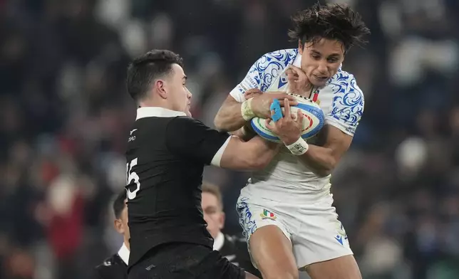 New Zealand's Will Jordan, left, and Italy's Ange Capuozzo compete for the ball during the Autumn Nations Series rugby union match between Italy and the All Blacks at the Allianz stadium, in Turin, Italy, Saturday, Nov. 23, 2024. (AP Photo/Luca Bruno)