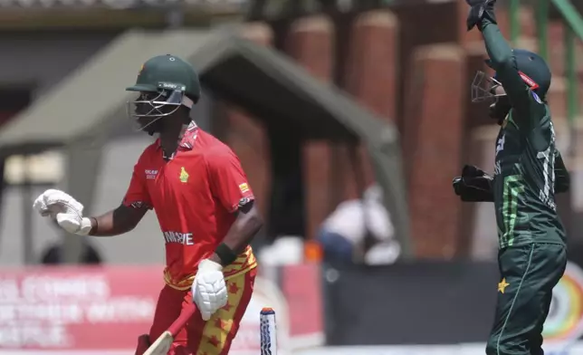 Zimbabwe's Dion Myers, left, in front of Pakistan's wicket keeper Mohammad Rizwan, right, during the second ODI cricket match between Zimbabwe and Pakistan at Queens Sports Club in Bulawayo, Zimbabwe, Tuesday, Nov. 26, 2024. (AP Photo/Wonder Mashura)