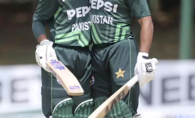 Pakistan's Saim Ayub and Abdullah Shafique hug each other during the second ODI cricket match between Zimbabwe and Pakistan at Queens Sports Club in Bulawayo, Zimbabwe, Tuesday, Nov. 26, 2024. (AP Photo/Wonder Mashura)