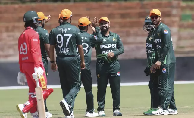 Zimbabwe's Tadiwanashe Marumani, left, leaves the field during the second ODI cricket match between Zimbabwe and Pakistan at Queens Sports Club in Bulawayo, Zimbabwe, Tuesday, Nov. 26, 2024. (AP Photo/Wonder Mashura)