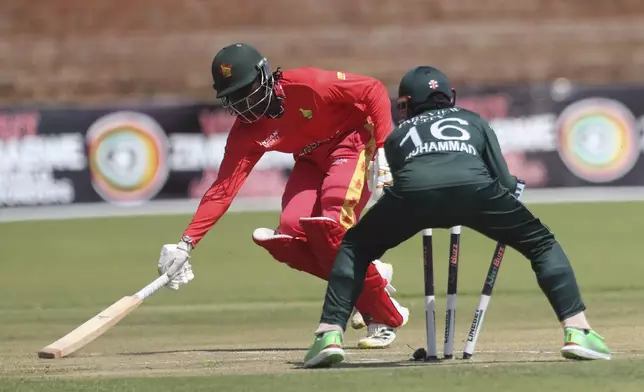 Zimbabwe's Tadiwanashe Marumani, back, reaches for the crease in front of Pakistan's wicket keeper during the second ODI cricket match between Zimbabwe and Pakistan at Queens Sports Club in Bulawayo, Zimbabwe, Tuesday, Nov. 26, 2024. (AP Photo/Wonder Mashura)