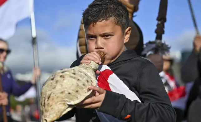 Te Haukūnui Hokianga plays a conch shell ahead of a protest at New Zealand's parliament against a proposed law that would redefine the country's founding agreement between Indigenous Māori and the British Crown, in Wellington, New Zealand, Tuesday, Nov. 19, 2024. (AP Photo/Mark Tantrum)