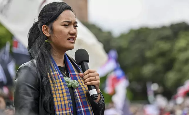 Hana-Rāwhiti Maipi-Clarke speaks to the thousands of people gathered outside New Zealand's parliament to protest a proposed law that would redefine the country's founding agreement between Indigenous Māori and the British Crown, in Wellington Tuesday, Nov. 19, 2024. (AP Photo/Mark Tantrum)