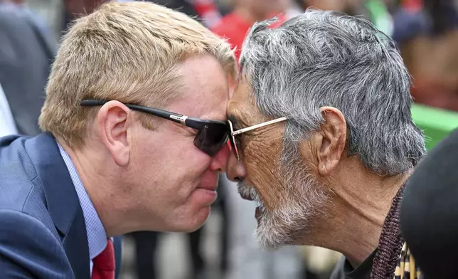 New Zealand's opposition leader Chris Hipkins, left, does a hongi with Hare Arapere as people gathered outside New Zealand's parliament to protest a proposed law that would redefine the country's founding agreement between Indigenous Māori and the British Crown, in Wellington Tuesday, Nov. 19, 2024. (AP Photo/Mark Tantrum)