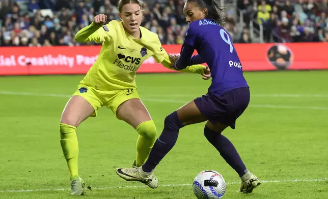 Washington Spirit midfielder Hal Hershfelt, left, and Orlando Pride forward Adriana (9) battle for control of the ball during the second half of the NWSL championship soccer game at CPKC Stadium, Saturday, Nov. 23, 2024, in Kansas City, Mo. (AP Photo/Reed Hoffmann)