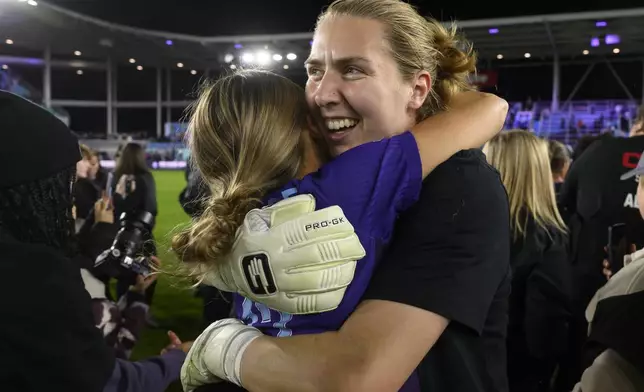 Orlando Pride goalkeeper Anna Moorhouse, right, hugs Pride defender Carrie Lawrence after they defeated the Washington Spirit in the NWSL championship soccer game at CPKC Stadium, Saturday, Nov. 23, 2024, in Kansas City, Mo. (AP Photo/Reed Hoffmann)