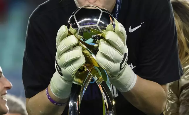 Orlando Pride goalkeeper Anna Moorhouse kisses the trophy after the team defeated the Washington Spirit in the NWSL championship soccer game at CPKC Stadium, Saturday, Nov. 23, 2024, in Kansas City, Mo. (AP Photo/Reed Hoffmann)