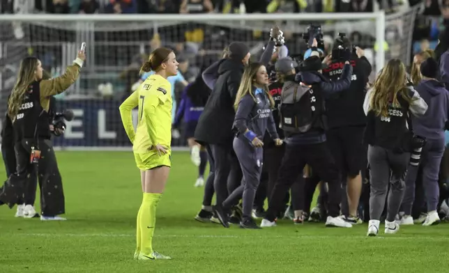 Washington Spirit midfielder Hal Hershfelt, center left, looks on as the Orlando Pride celebrates after winning the NWSL championship soccer game at CPKC Stadium, Saturday, Nov. 23, 2024, in Kansas City, Mo. (AP Photo/Reed Hoffmann)