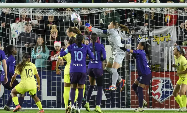 Washington Spirit goalkeeper Aubrey Kingsbury, in grey, clears the ball during the first half of the NWSL championship at CPKC Stadium against the Orlando Pride, Saturday, November 23, 2024, in Kansas City, Mo. (AP Photo/Reed Hoffmann)