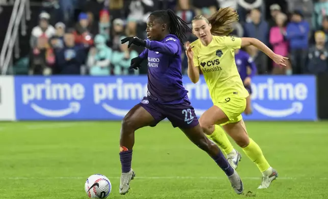 Orlando Pride forward Barbra Banda (22) runs past Washington Spirit defender Tara McKeown (9) during the second half of the NWSL championship at CPKC Stadium, Saturday, November 23, 2024, in Kansas City, Mo. (AP Photo/Reed Hoffmann)