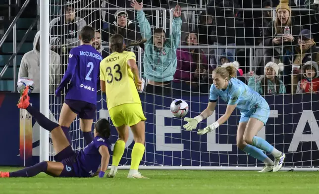 Orlando Pride goalkeeper Anna Moorhouse, right, blocks a shot on goal by Washington Spirit during the second half of the NWSL championship soccer game at CPKC Stadium, Saturday, Nov. 23, 2024, in Kansas City, Mo. (AP Photo/Reed Hoffmann)