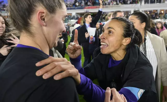 Orlando Pride forward Marta, right, celebrates with midfielder Morgan Gautrat, left, after they defeated the Washington Spirit in the NWSL championship soccer game at CPKC Stadium, Saturday, Nov. 23, 2024, in Kansas City, Mo. (AP Photo/Reed Hoffmann)