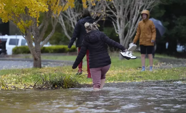 Pedestrians cross a flooded street during a storm Thursday, Nov. 21, 2024, in Santa Rosa, Calif. (AP Photo/Jeff Chiu)