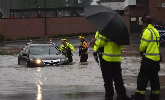 A rescue team help a stranded motorist in a flooded street during a storm Thursday, Nov. 21, 2024, in Santa Rosa, Calif. (AP Photo/Jeff Chiu)