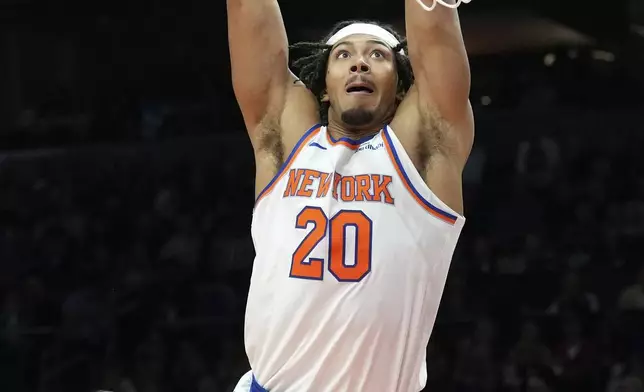 New York Knicks center Jericho Sims (20) dunks against Phoenix Suns guard Monte Morris during the first half of an NBA basketball game Wednesday, Nov. 20, 2024, in Phoenix. (AP Photo/Ross D. Franklin)