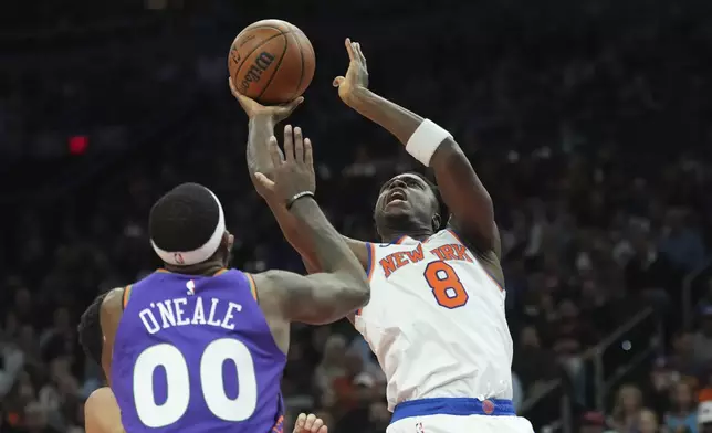 New York Knicks forward OG Anunoby (8) shoots over Phoenix Suns forward Royce O'Neale (00) during the first half of an NBA basketball game Wednesday, Nov. 20, 2024, in Phoenix. (AP Photo/Ross D. Franklin)