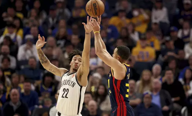 Golden State Warriors guard Stephen Curry, right, looks to shoot against Brooklyn Nets forward Jalen Wilson (22) during the first half of an NBA basketball game in San Francisco, Monday, Nov. 25, 2024. (AP Photo/Jed Jacobsohn)