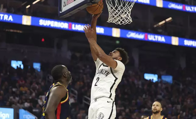 Brooklyn Nets forward Cameron Johnson (2) shoots against Golden State Warriors forward Draymond Green, left, during the first half of an NBA basketball game in San Francisco, Monday, Nov. 25, 2024. (AP Photo/Jed Jacobsohn)