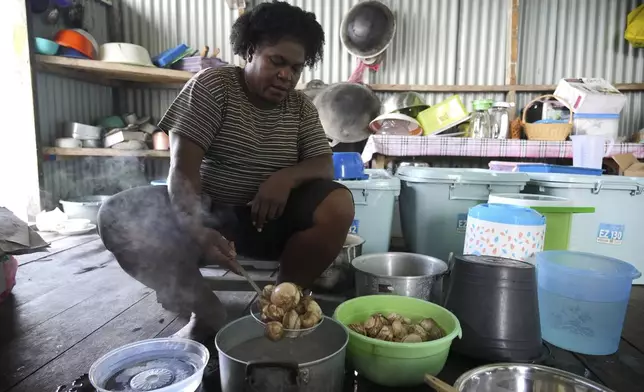 Petronela Merauje prepares clams to cook at her house at Enggros village in Jayapura, Papua province, Indonesia on Wednesday, Oct. 2, 2024. (AP Photo/Firdia Lisnawati)